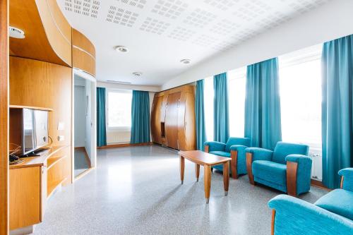 a hospital room with blue chairs and a television at Spa Hotel Härmä - Härmän Kylpylä in Ylihärmä