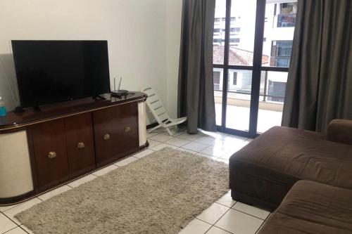 Una televisión o centro de entretenimiento en Apartamento Quadra Mar Itapema