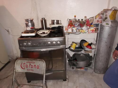 a stove in a kitchen with a bunch of dishes at Suit compartida con amenidades in Mexico City