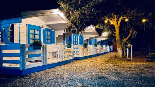 a blue and white house with a fence and a tree at Manu B&B in Murighiol