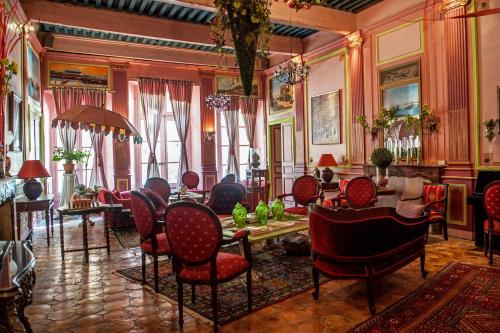 - un salon avec des chaises et des tables rouges dans un bâtiment dans l'établissement Demeure de Digoine "Chambre d'Hotes", à Bourg-Saint-Andéol