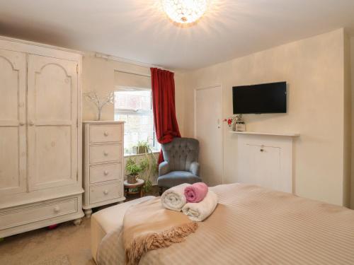 ein Schlafzimmer mit einem Bett, einem Stuhl und einem TV in der Unterkunft 21 Florence Road in Lowestoft