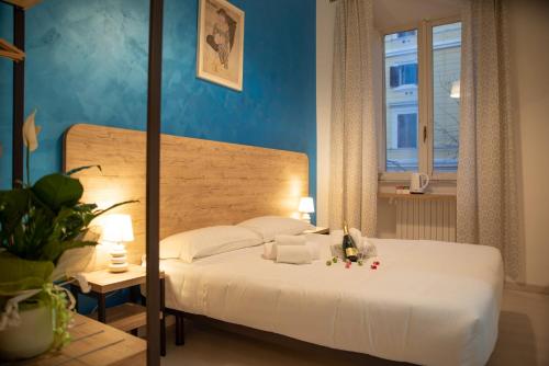 um quarto com uma cama branca e uma parede azul em Romerooms em Roma