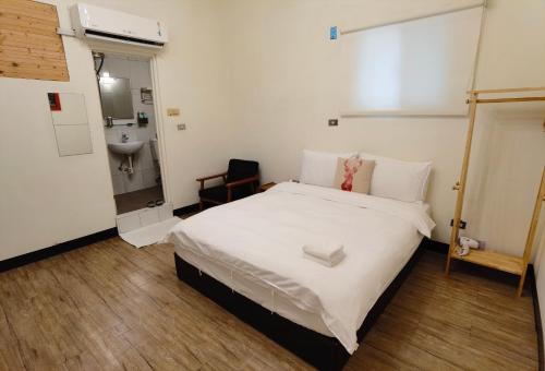 Habitación pequeña con cama y lavamanos en OC Hostel, en Tainan