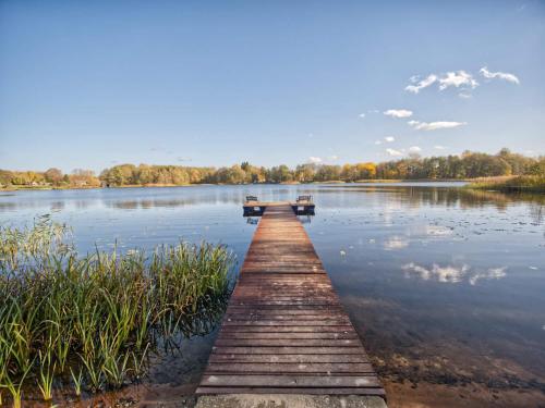 ein Holzsteg in der Mitte eines Sees in der Unterkunft Przystań Nad Zatoką - Gospodarstwo Agroturystyczne in Lubieszewo