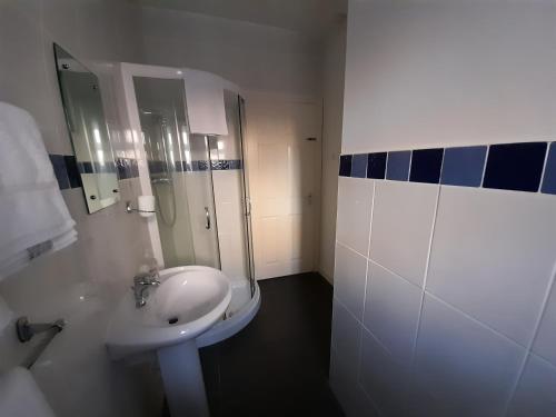 a white bathroom with a sink and a shower at Little Parklands Apt2 in Sandown