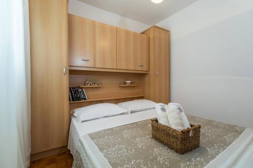 - une chambre avec un lit doté d'oreillers blancs et d'une armoire dans l'établissement Sunny House, à Korčula
