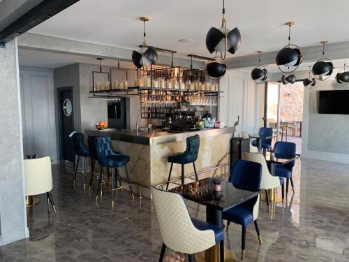 a restaurant with a bar with blue chairs and tables at Lux Apartments Pinctada in Dobra Voda