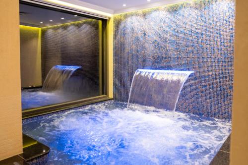 a bathroom with a tub with a waterfall at Amman International Hotel in Amman
