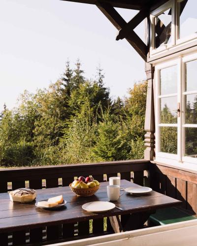 a wooden table with a bowl of fruit on a porch at 2 Chalets Innsbruck in Innsbruck