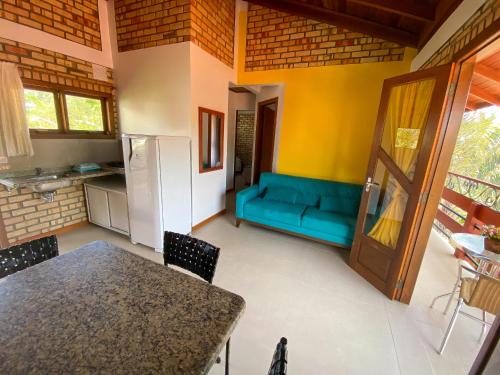 a living room with a blue couch and a table at Pousada Portal Sul in Florianópolis