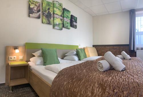 um quarto com uma cama grande e almofadas verdes e brancas em Hotel Dolce Vita em Balatonkenese