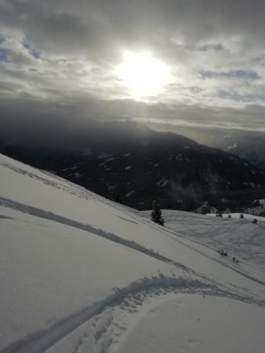 a snow covered slope with the sun in the background at Apartment Lacklhof in Großkirchheim