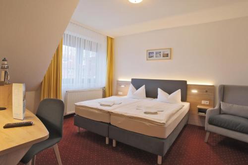 ein Hotelzimmer mit einem Bett und zwei Stühlen in der Unterkunft Hotel & Restaurant Am Wasser in Breege