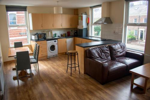 a kitchen and living room with a couch and a table at Titanic Apartments Belfast in Belfast