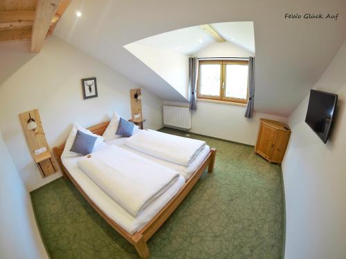 舍瑙阿姆克尼格塞的住宿－Gästehaus Siegllehen，阁楼上的卧室配有一张大床