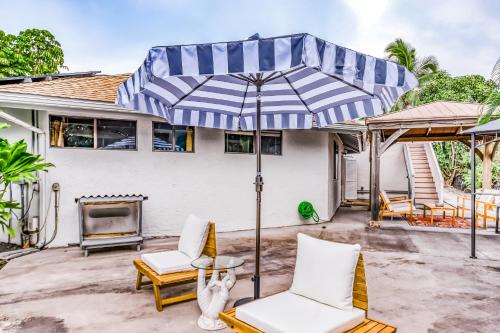 a patio with two chairs and an umbrella at Kona Paradise in Kailua-Kona