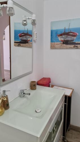 a bathroom with a white sink and a mirror at Casa de Mar in Olhão