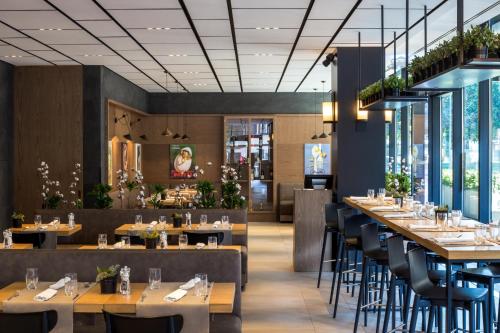 a dining room with tables and chairs and windows at Maritim Hotel Plaza Tirana in Tirana