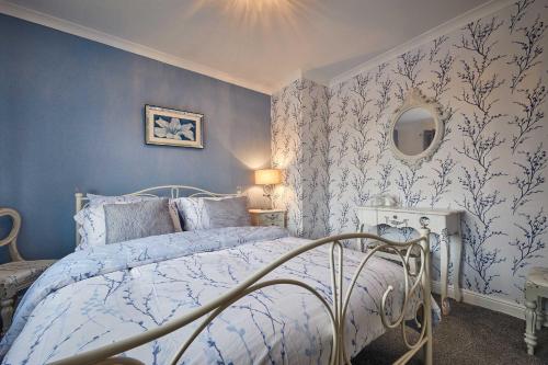 a bedroom with a bed with blue walls and a mirror at Host & Stay - Stonehaven in Seaton Carew