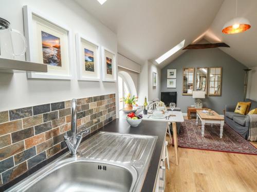 a kitchen with a sink and a living room at Little Brook in Broadwey