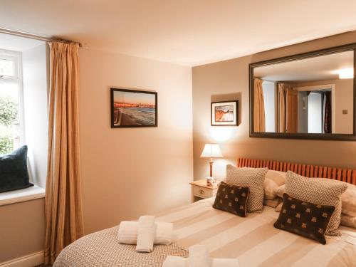 ein Schlafzimmer mit einem Bett und einem Spiegel an der Wand in der Unterkunft Little Brook in Broadwey