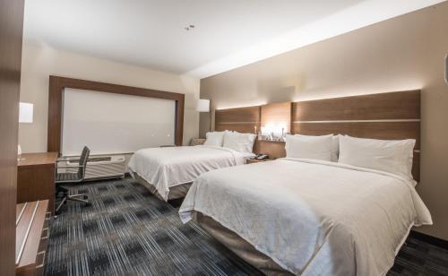 a hotel room with two beds and a projection screen at Holiday Inn Express & Suites - Houston Westchase - Westheimer by IHG in Houston