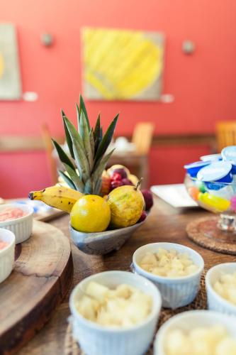 a table topped with bowls of fruit and a banana at Pousada da Cyssa in Búzios