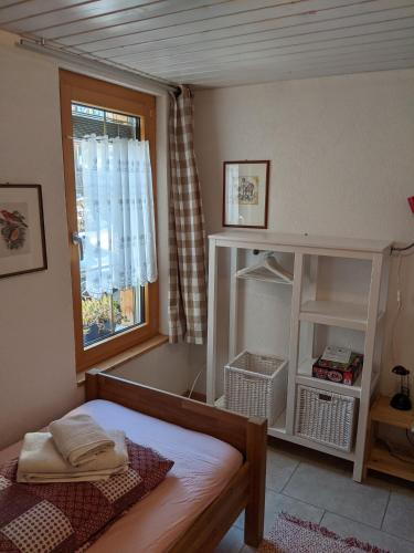a small bedroom with a bed and a window at Casa Acazia in Brigels