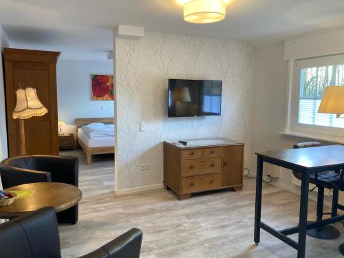 a living room with a tv on a wall at Hotel Wintersmühle in Bielefeld