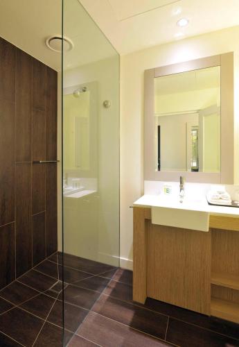 a bathroom with a sink and a shower at Mercure Portsea & Portsea Golf Club in Portsea