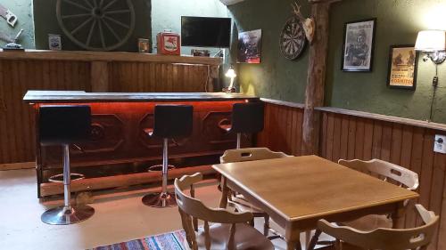 a table and chairs in a room with a wooden bar at Pension Leano in Nötsch