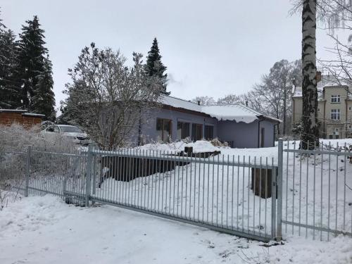 a fence in front of a house covered in snow at Bungalov v Krásné Lípě in Krásná Lípa