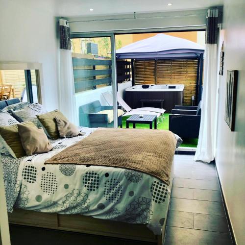 - une chambre avec un lit et une vue sur une terrasse dans l'établissement Cap Paradise suite jacuzzi, au Cap d'Agde
