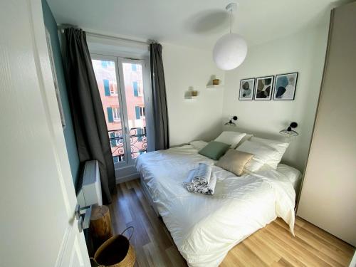 ein Schlafzimmer mit einem weißen Bett und einem Fenster in der Unterkunft Sunny and calm 2 bed apartment place du Pin in Nizza