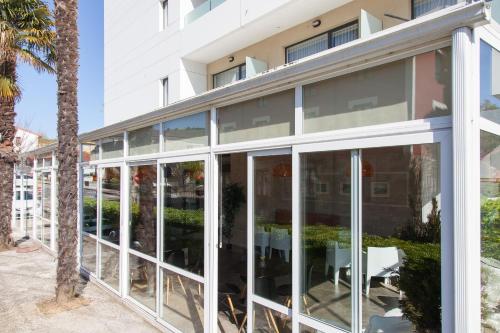 a building with glass doors and a palm tree at Hotel Miera in Liérganes