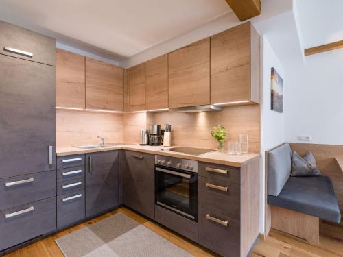 a kitchen with wooden cabinets and stainless steel appliances at Pension Hinterholzer in Scheffau am Wilden Kaiser