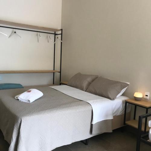 a bedroom with a bed and a side table at Maná Mariscal Hospedagem in Bombinhas