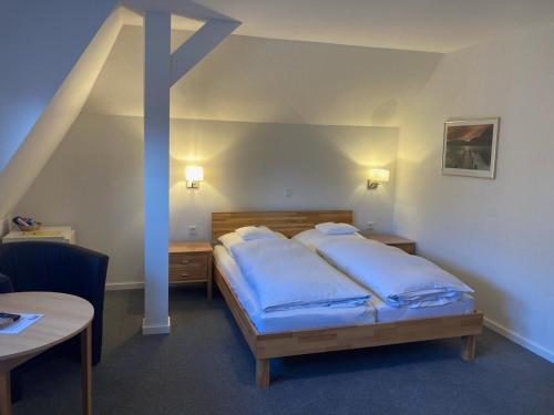 a bedroom with a bed with blue pillows on it at Hotel Wintersmühle in Bielefeld