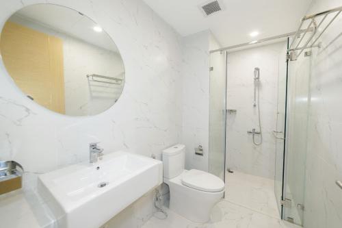 bagno con lavandino, servizi igienici e specchio di TMS Quy Nhon - Ngoc Lan Apartments a Quy Nhon