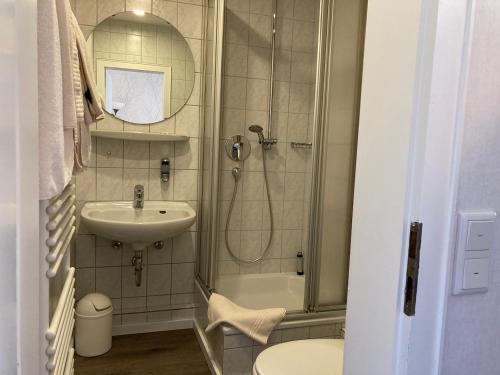 a bathroom with a shower and a sink and a toilet at Hotel Wintersmühle in Bielefeld