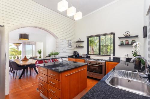 a kitchen with a sink and a table in it at Privilege Casa da Videira with Swimming Pool, Quelfes - Olhão in Olhão