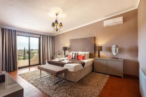 a bedroom with a bed and a large window at Privilege Casa da Videira with Swimming Pool, Quelfes - Olhão in Olhão