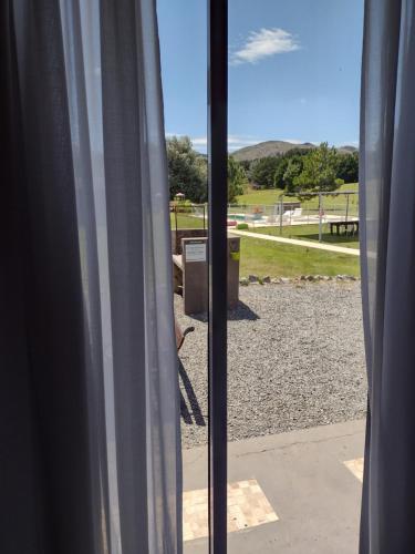 a window with a view of a park seen through it at Abril Village in Tandil