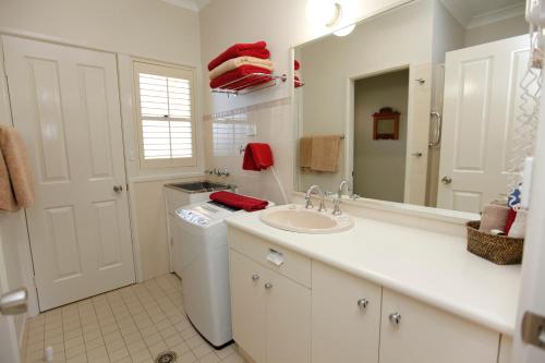 a bathroom with a sink and a toilet and a mirror at Country Apartments in Dubbo