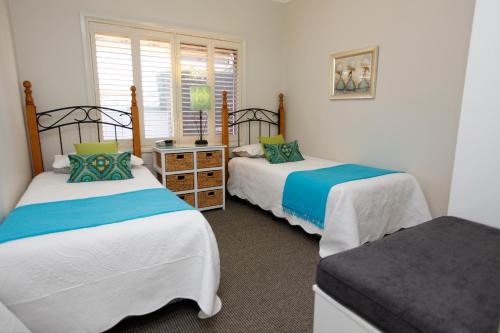 a bedroom with two beds and a window at Country Apartments in Dubbo
