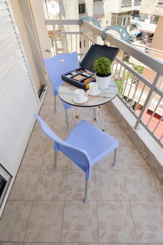 a table and chairs on a balcony with a laptop at Vento di Mare in Perea