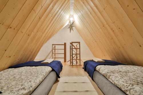 Dos camas en una habitación con techo de madera. en Dom na Wichrowym Wzgórzu, en Łętownia Dolna