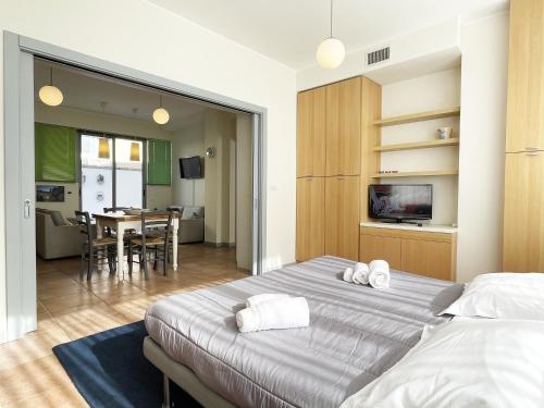 a bedroom with two beds and a dining room at Euphorbia Residence in Lecce