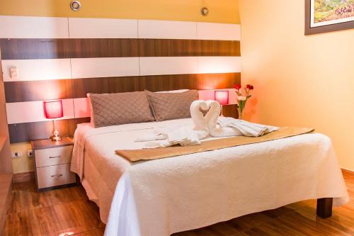 Un dormitorio con una cama con dos cisnes. en Serk'ana Suite Hostal, en Arequipa